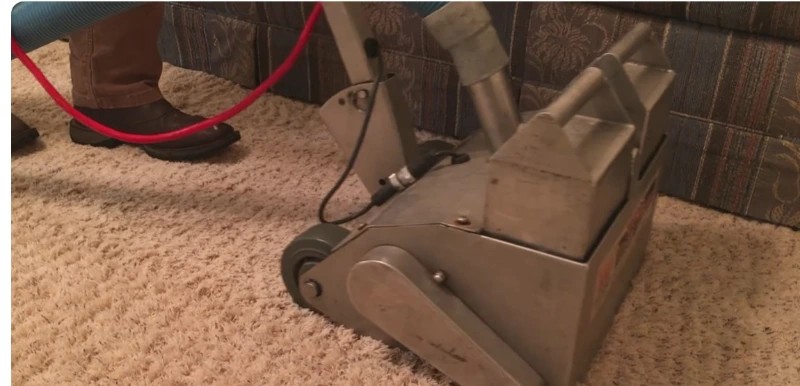 Weighted extraction wand pulling water out of soaked carpet in a Burleson home